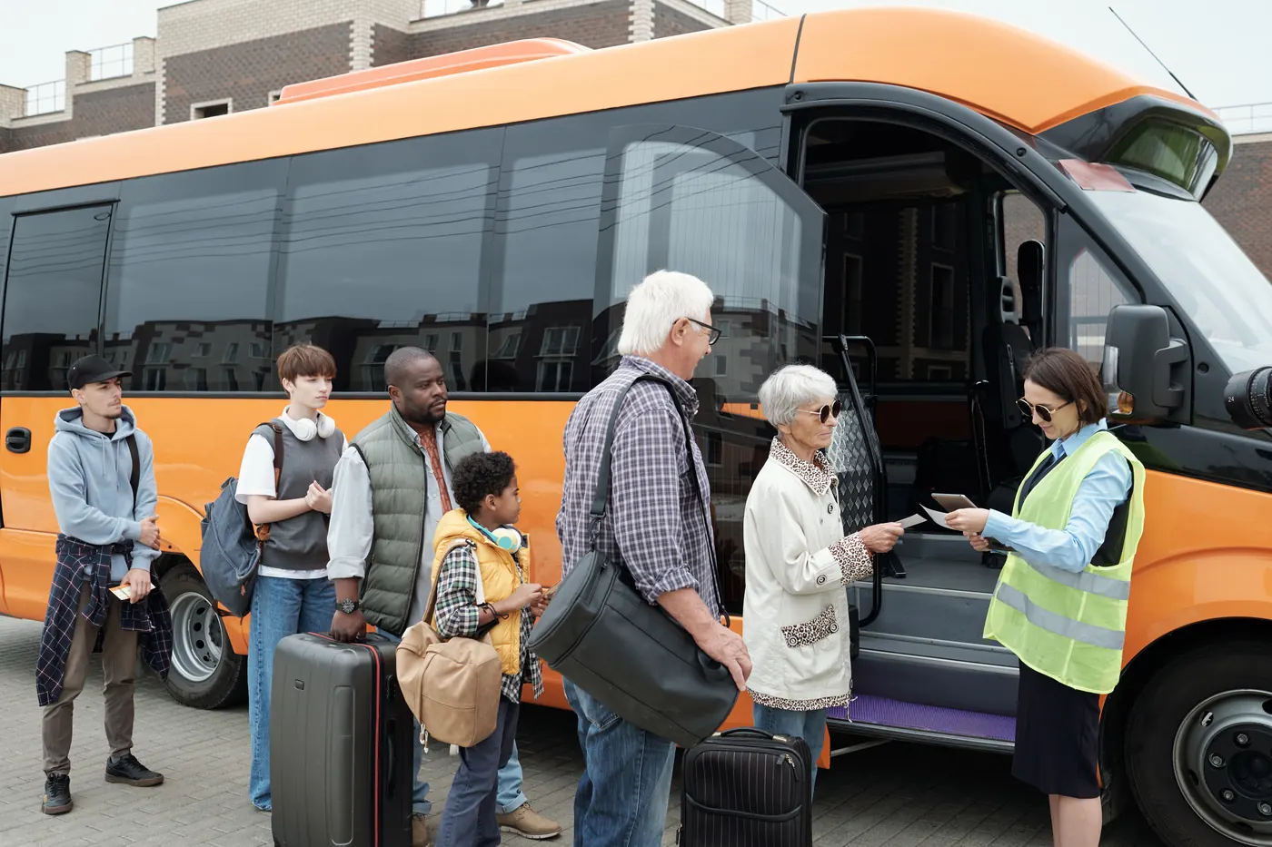 Pasajeros abordando un autobús de ruta mientras la operadora revisa los boletos